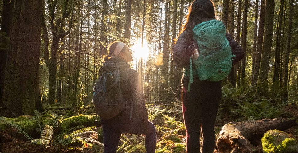 Two women hiking in a forest after a work day, an example of the Vancouver Lifestyle
