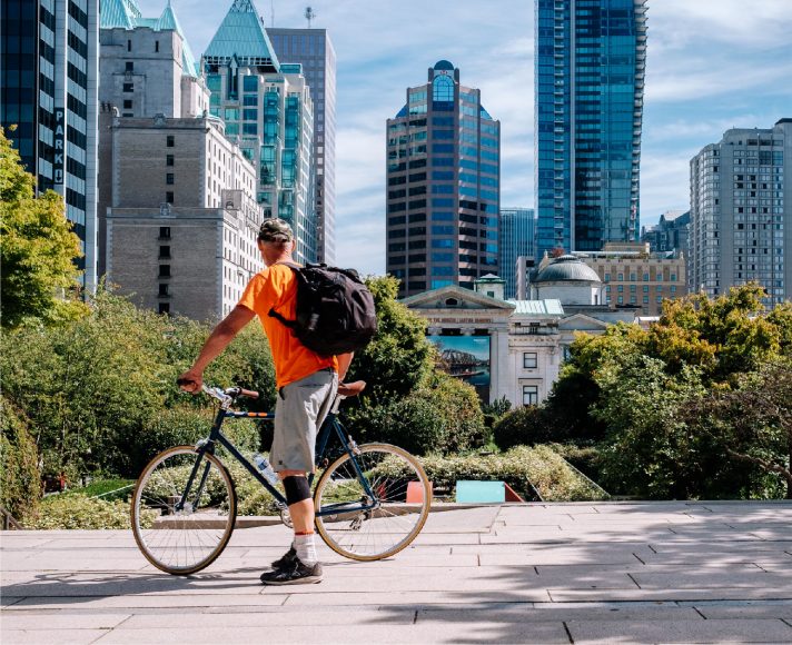 Vancouver Where Lifestyle and Business Come together | Man on a bike in Vancouver looking at the city skyline