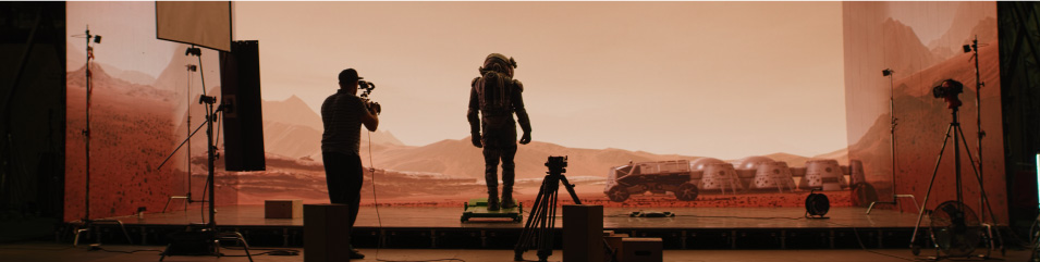 A film set designed to look like mars with a camera man and an astronaught are in position