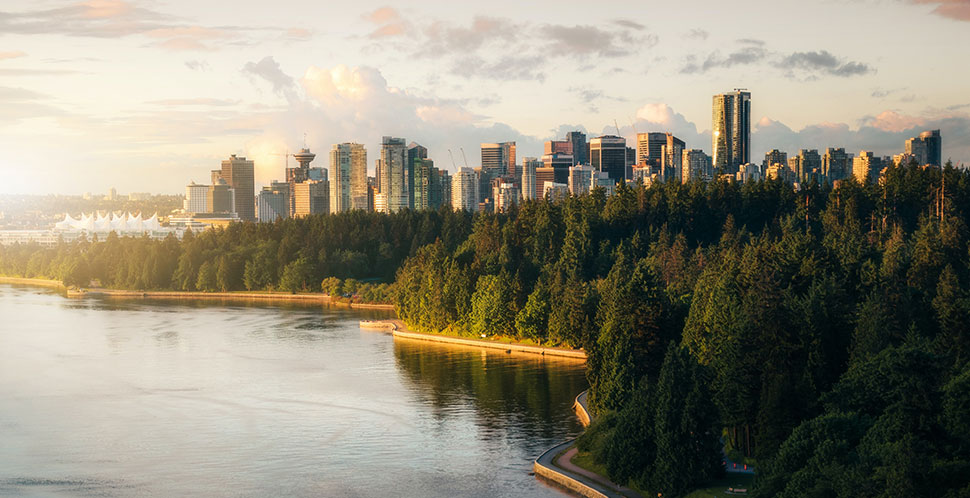 A photograph of a birds-eye view of Vancouver's skyline with the sun setting in the horizon